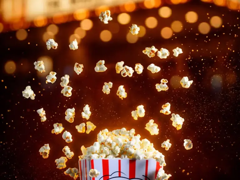 Pop-corn devant une enseigne lumineuse de cinéma — films X et VOD adulte illimitée